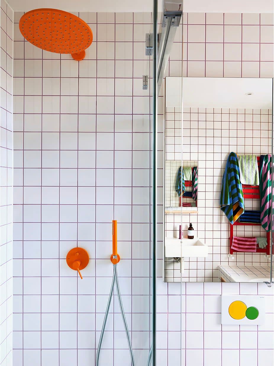 White-tiled bathroom with bright, multi-color grout and fixtures.