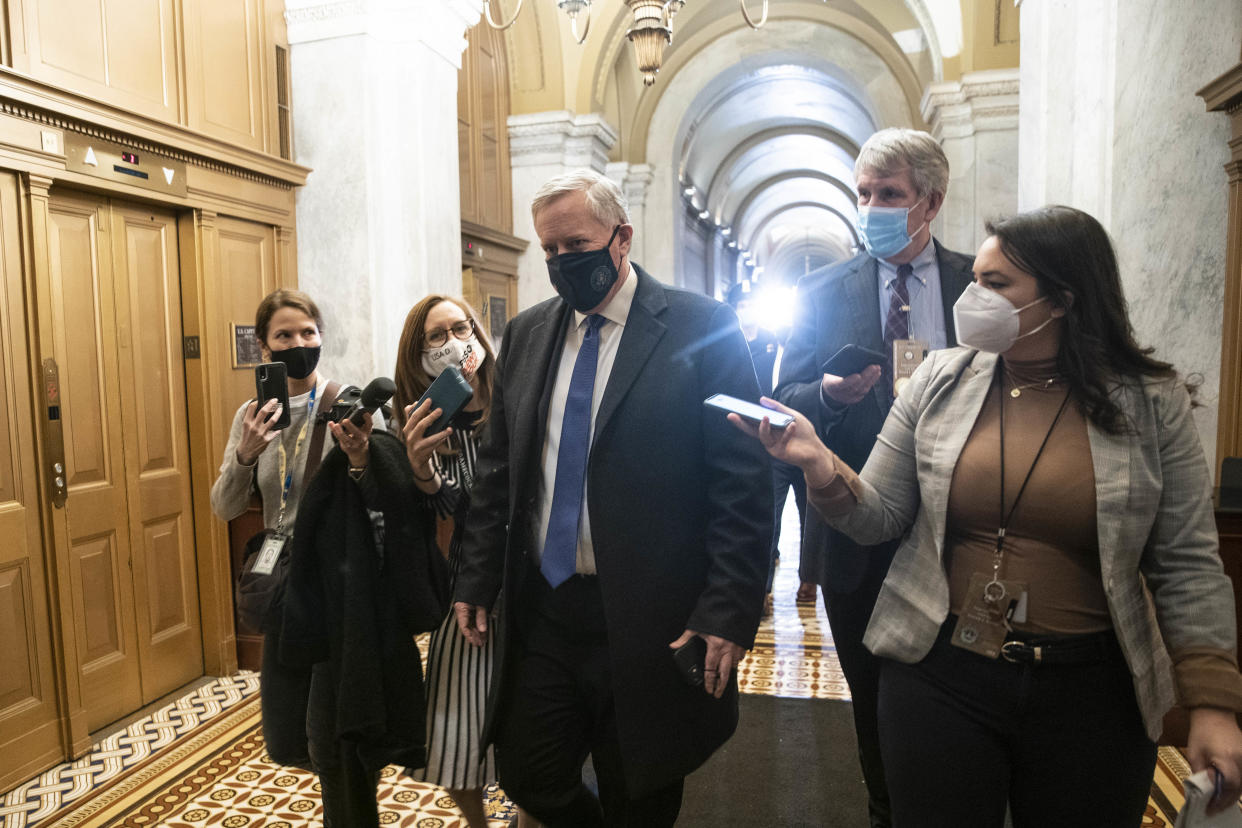 Former White House chief of staff Mark Meadows, with reporters holding up their cellphones to record him, wearing a mask, departs the U.S. Capitol during the second impeachment trial of former President Donald Trump.