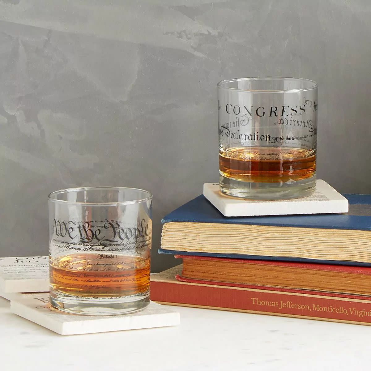 Constitution and Declaration drinking Glasses filled with possibly whiskey on stacked old books