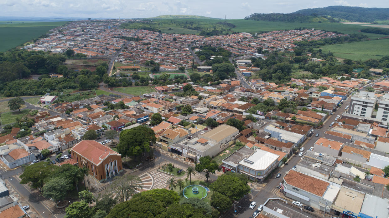 A church, left, stands in Serrana, Sao Paulo state, Brazil, Wednesday, Feb. 17, 2021. Brazil's Butantan Institute has started a mass vaccination on Wednesday of the city's entire adult population, about 30,000 people, to test the virus' behavior in response to the vaccine. (AP Photo/Andre Penner)