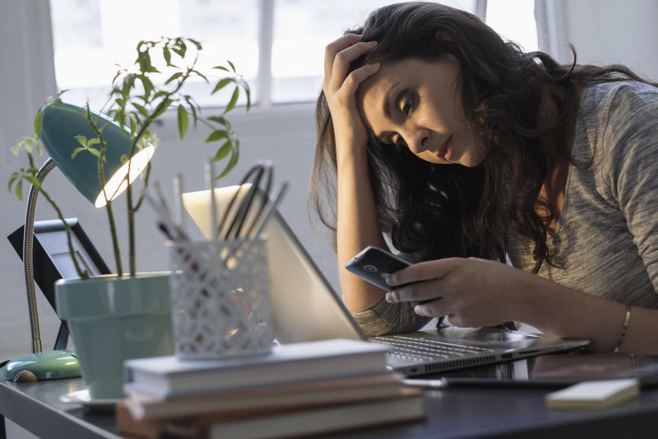 Hispanic businesswoman using technology in office