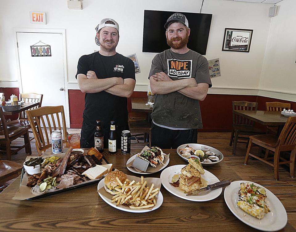 Owners of 2 Jerks BBQ Chris and John DePalma, pictured at the restaurant with a selection of menu items in 2017.