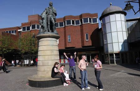 People gather under The Burns and Wilson Monument outside the Burns Shopping Mall in Kilmarnock, Scotland April 29, 2014. REUTERS/Suzanne Plunkett