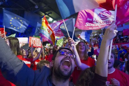 Supporters wave flags for Benoit Hamon, the French Socialist party 2017 presidential candidate who attends a campaign rally in Villeurbanne, near Lyon, France, April 11, 2017. REUTERS/Emmanuel Foudrot