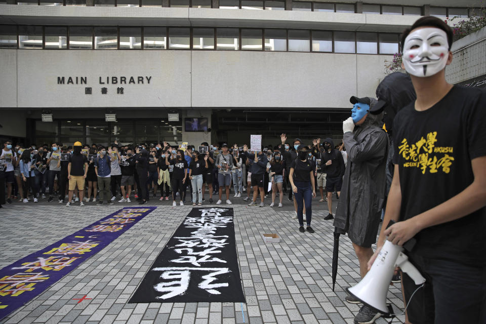 Pro-democracy university students gather at the campus of the University of Hong Kong, Wednesday, Nov. 6, 2019, against police brutality. Hong Kong police say an anti-government supporter stabbed and wounded a pro-Beijing Hong Kong lawmaker who was campaigning for local elections Wednesday, marking another escalation in five months of protests. The banner with Chinese reads: "Investigate police brutality.". (AP Photo/Kin Cheung)