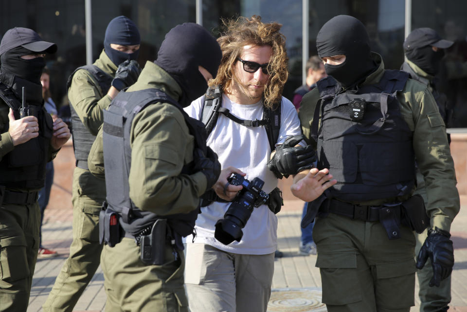 Police officers detain a photojournalist during an opposition rally to protest the official presidential election results in Minsk, Belarus, Saturday, Sept. 26, 2020. Hundreds of thousands of Belarusians have been protesting daily since the Aug. 9 presidential election. (AP Photo/TUT.by)