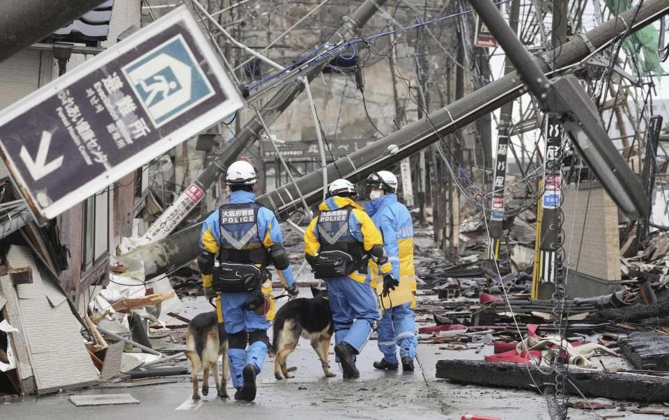 Police officers conduct a search operation in Wajima, Ishikawa prefecture, Japan Sunday, Jan. 7, 2024. A major earthquake slammed western Japan on Jan. 1, killing scores of people, toppling buildings and setting off landslides. (Kyodo News via AP)