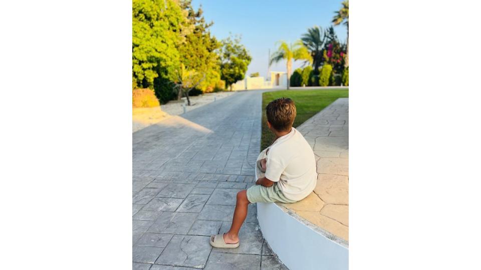 young boy sitting on stone wall 