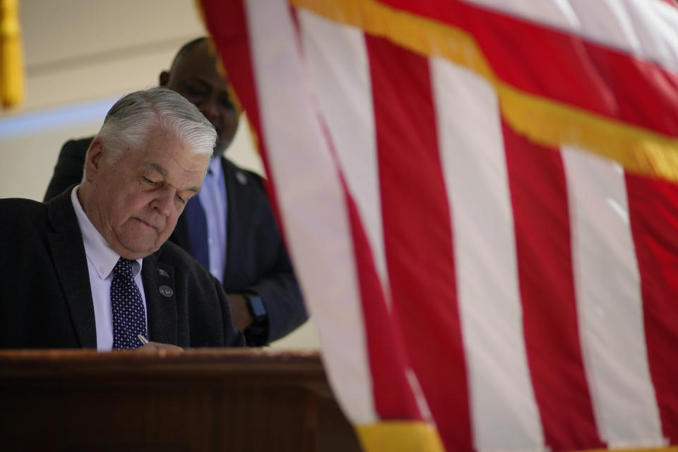 Nevada Democratic Gov. Steve Sisolak signs one of several bills into law at a signing ceremony Friday, June 11, 2021, in Las Vegas. One of the new laws would make Nevada the first to vote on the 2024 presidential primary contests, though national political parties would need to agree to changes in the calendar or state parties could risk losing their delegates at presidential nominating conventions. (AP Photo/John Locher)