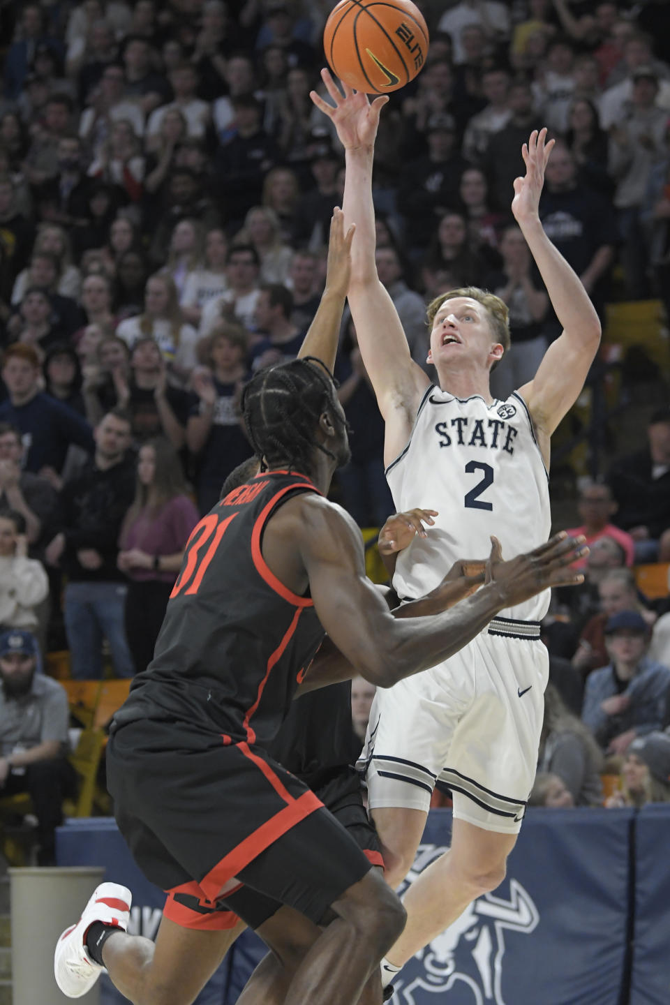 Utah State guard Sean Bairstow (2) shoots as San Diego State forward Nathan Mensah (31) defends during the second half of an NCAA college basketball game Wednesday, Feb. 8, 2023, in Logan, Utah. (AP Photo/Eli Lucero)