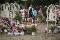 People visit a memorial outside Robb Elementary School in Uvalde, Texas, Monday, May 30, 2022. On May 24, 2022, an 18-year-old entered the school and fatally shot several children and teachers. (AP Photo/Wong Maye-E)