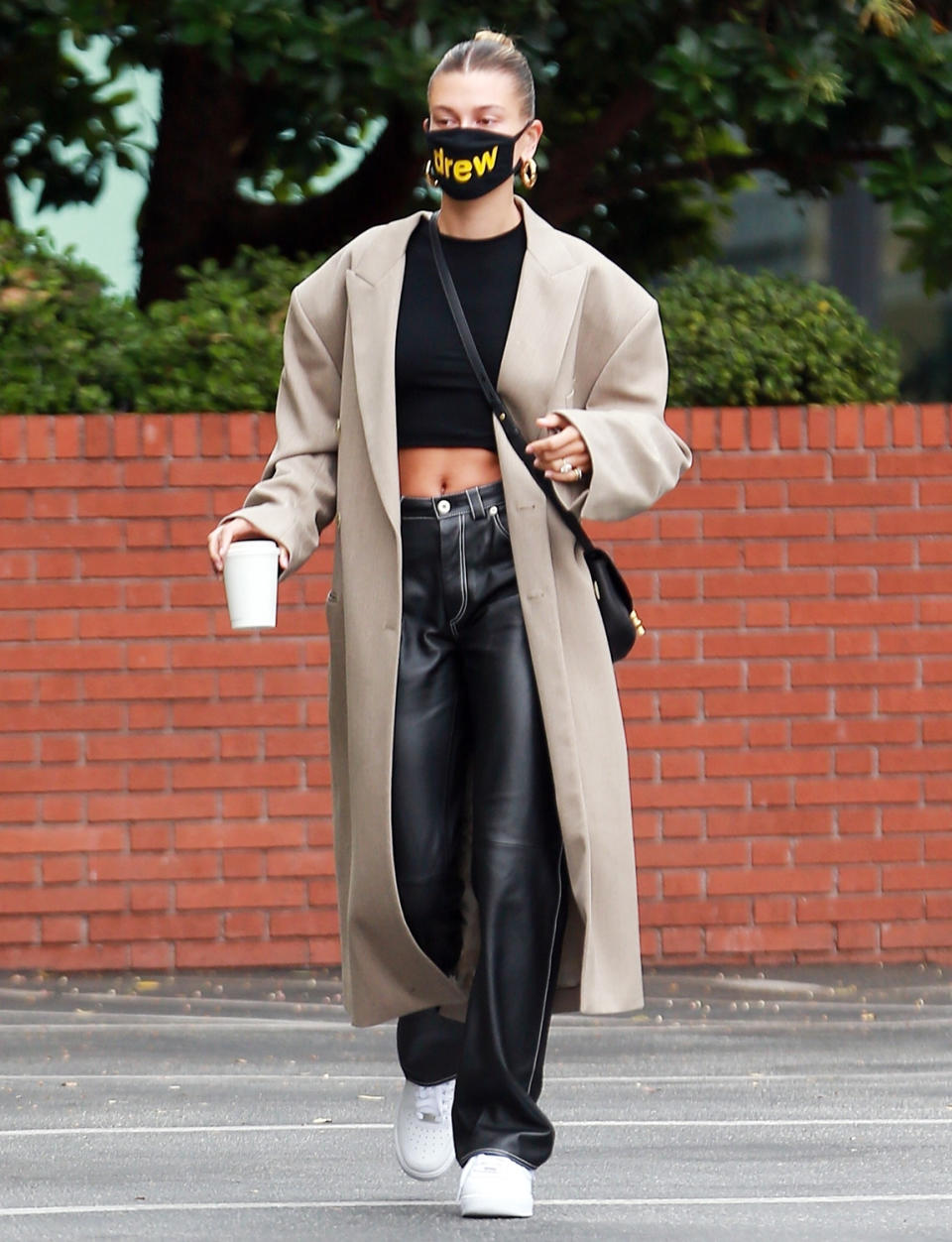 <p>Back from a photo shoot in Italy, Hailey Bieber makes a Sunday morning trip to Blue Bottle Cafe in Beverly Hills while looking chic in a sleek bun and long coat.</p>