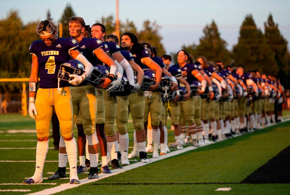 Puyallup players stand on the sideline for the national anthem before the start of the season opener game at Sparks Stadium in Puyallup Wash. on Sept. 2, 2022.