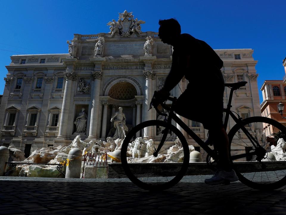 FILE PHOTO: A cyclist passes the Trevi Fountain, as Italy begins to ease some of the restrictions of the coronavirus disease (COVID-19) lockdown, in Rome, Italy May 7, 2020. REUTERS/Guglielmo Mangiapane - RC2QJG9FV9WK/File Photo