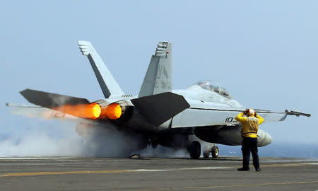 A U.S. Navy F18 fighter jet takes off from aircraft carrier USS Carl Vinson during a FONOPS in the South China Sea. REUTERS/Erik De Castro