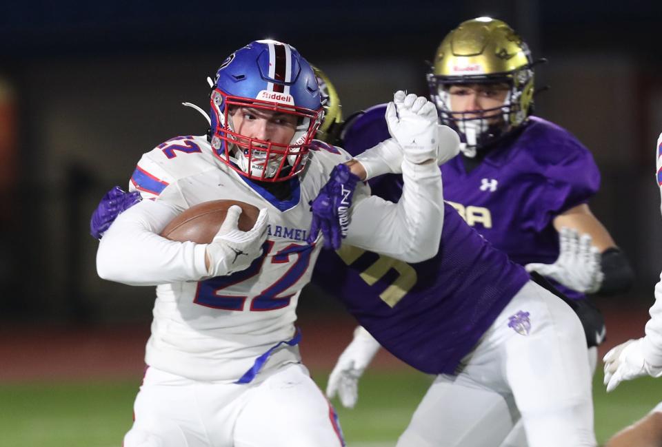 Carmel's Tristan Werlau (22) runs back a kick-off for a first half touchdown against Christian Brothers Academy during the Class AA state semifinal playoff game at Middletown High School Nov. 25, 2023.