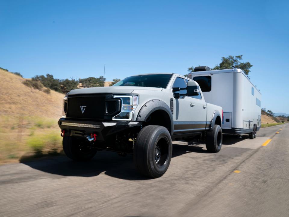 The travel trailer being towed by a truck on the road.