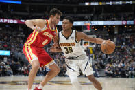 Denver Nuggets guard P.J. Dozier, right, drives against Atlanta Hawks forward Danilo Gallinari during the second half of an NBA basketball game Friday, Nov. 12, 2021, in Denver. (AP Photo/David Zalubowski)