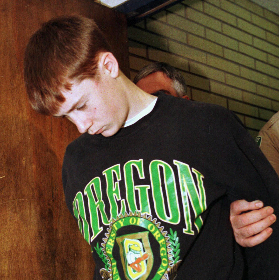 FILE - In this May 22, 1998, file photo, Thurston High School student Kip Kinkel, 15, is led to his arraignment in Eugene, Ore. Kip Kinkel, who killed his parents before going on a shooting rampage at his Oregon high school in 1998, killing two classmates and injuring 25 more, has given his first news interview, telling HuffPost he feels “tremendous, tremendous shame and guilt.”(AP Photo/Don Ryan, File)