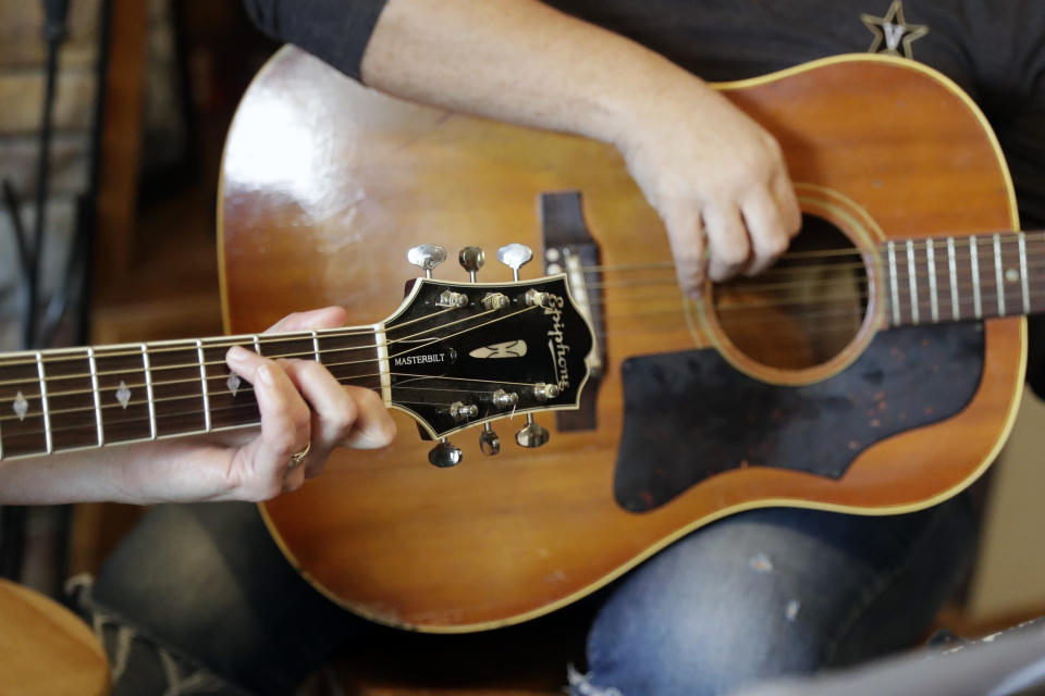 In this May 22, 2020, photo, nurse Megan Palmer, left, and care partner Anna Henderson, who both work at Vanderbilt University Medical Center, appear during a songwriting session at Henderson's home in Ashland City, Tenn. During the COVID-19 pandemic, their role as caregivers has become even more important as hospital visits from family and friends were limited or prohibited to prevent the spread of the virus. Music and songwriting has helped them express the complexity of emotions that comes with caregiving, especially in the time of a pandemic. (AP Photo/Mark Humphrey)