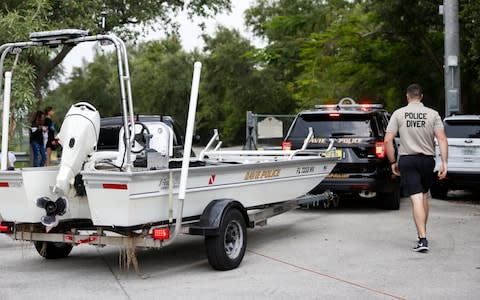 Police divers haul a boat to the entrance of Silver Lakes Rotary Nature Park on Friday - Credit: Wilfredo Lee/AP