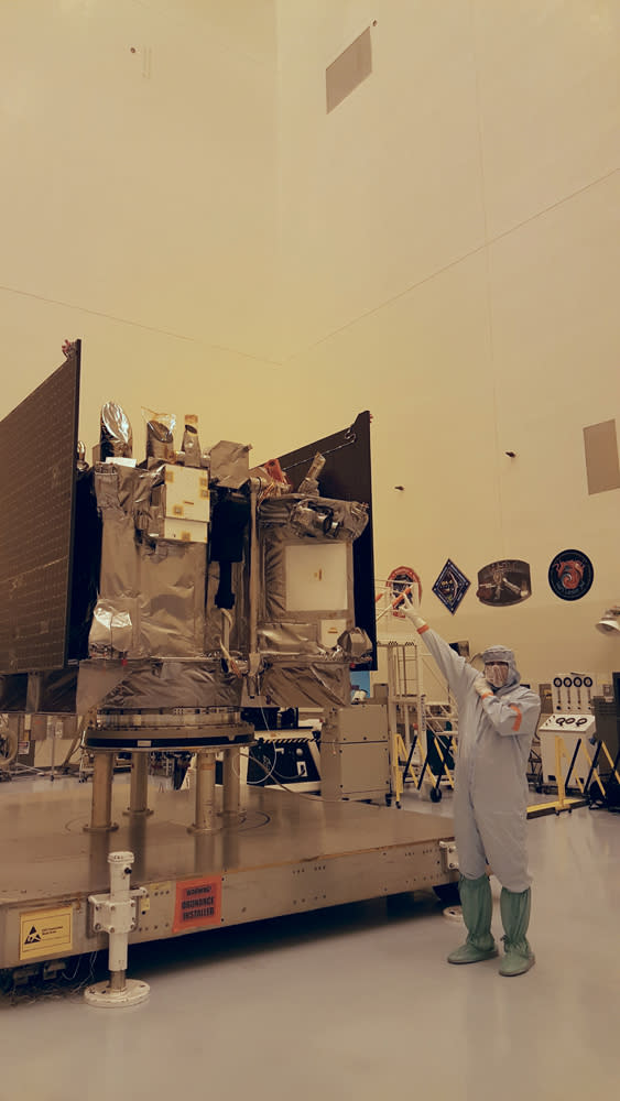 Rich Kuhns, OSIRIS-REx program manager for Lockheed Martin, points to the TAGSAM, a robotic arm that will gather a sample of the asteroid Bennu.