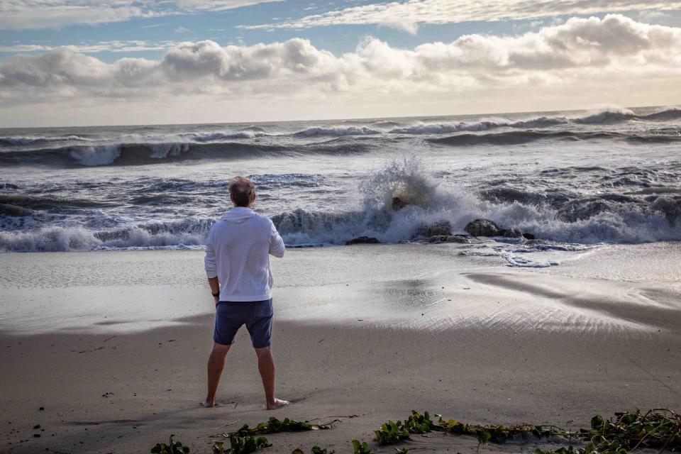 A man stands in the sand at Midtown Beach and observes the choppy waves of the Atlantic Ocean on Thursday.