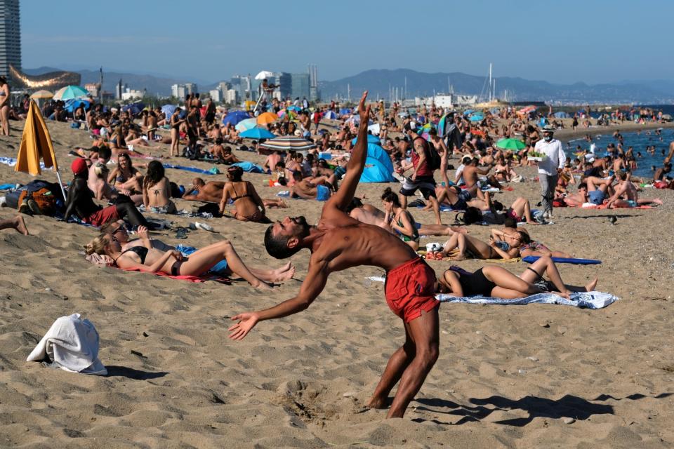 A man plays as he enjoys the sunny weather at Barceloneta beach (REUTERS)