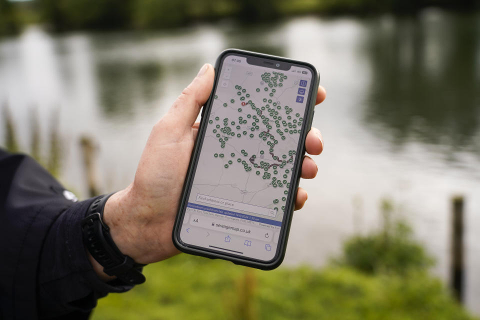 Endurance swimmer Joan Fennelly, member of the open water swimming group Henley Mermaids, shows a map of the river Thames on her smartphone, in Henley-on-Thames, England, Friday, June 14, 2024. Fennelly is undaunted by frigid water and long distances, swimming year-round in the wild. But she takes extra precautions in her own backyard. The River Thames is one of Britain's many waterways contaminated with sewage and agricultural pollution. (AP Photo/Alberto Pezzali)