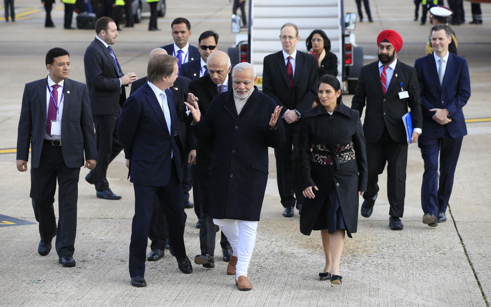 Indian Prime Minister Narendra Modi (centre) is flanked by Minister of State for the Foreign and Commonwealth Office, Hugo Swire (left) and Priti Patel (right) as he arrives at Heathrow Airport, London, for an official three day visit.