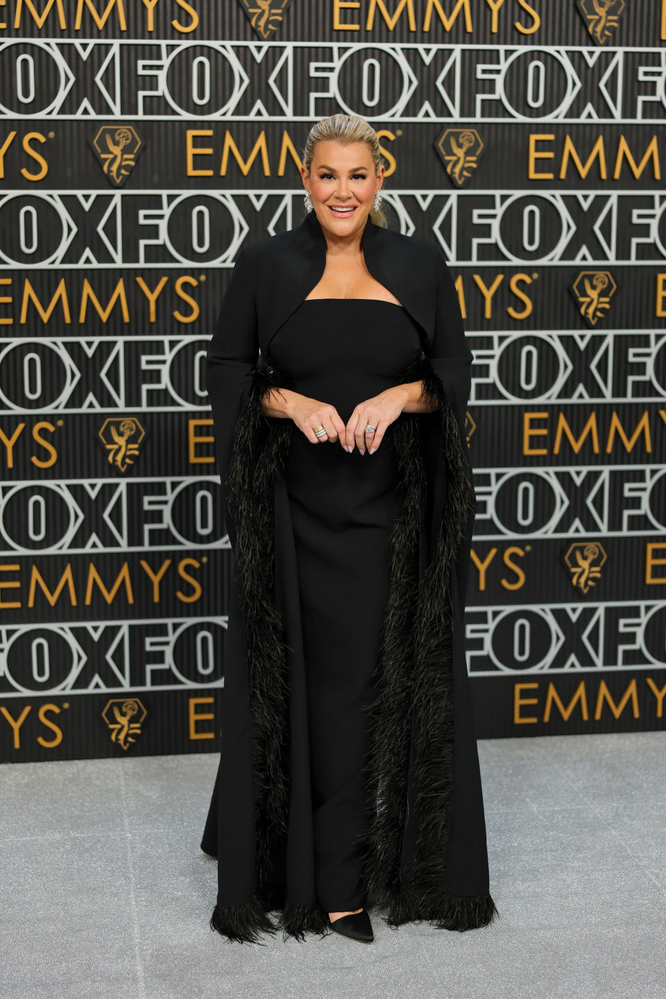 Heather McMahan wears a black gown with feathered sleeves at the back.  (Image from Getty Images)