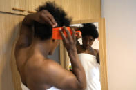 Guinean wrestler Fatoumata Yarie Camara adjusts her hair in her room of the Ostia's Olympic training center, near Rome, Monday, July 5, 2021. A West African wrestler's dream of competing in the Olympics has come down to a plane ticket. Fatoumata Yarie Camara is the only Guinean athlete to qualify for these Games. She was ready for Tokyo, but confusion over travel reigned for weeks. The 25-year-old and her family can't afford it. Guinean officials promised a ticket, but at the last minute announced a withdrawal from the Olympics over COVID-19 concerns. Under international pressure, Guinea reversed its decision. (AP Photo/Alessandra Tarantino)