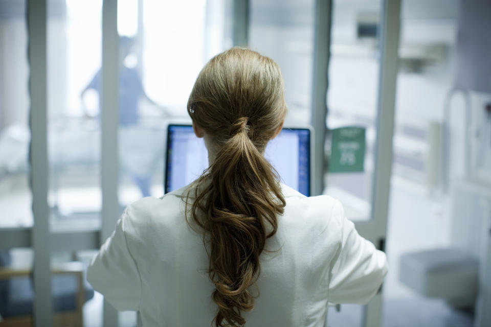 Healthcare professional working on a computer in a hospital setting