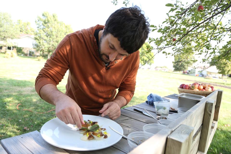 Here, Joe Tripp, at the time Alba's chef, prepares a dish of fresh herbs and vegetables at Grade A Gardens in 2013.