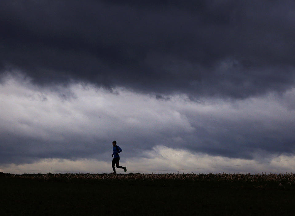 <p>A man runs on a small road between fields in the outskirts of Frankfurt, Germany, Feb. 22, 2017. Changing temperatures and strong winds are forecasted for the next days all over Germany. (Photo: Michael Probst/AP) </p>