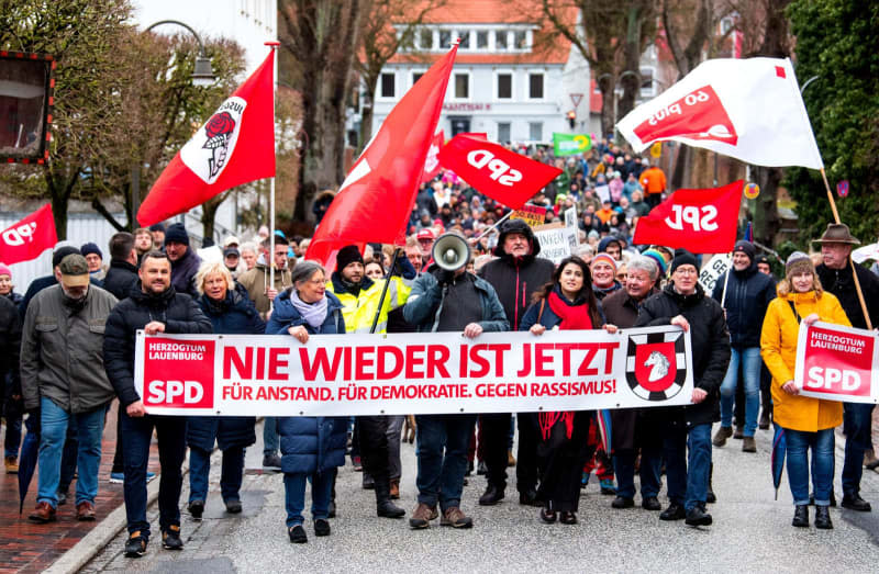 people hold flags and banner during a protest against right-wing extremism. Daniel Bockwoldt/dpa