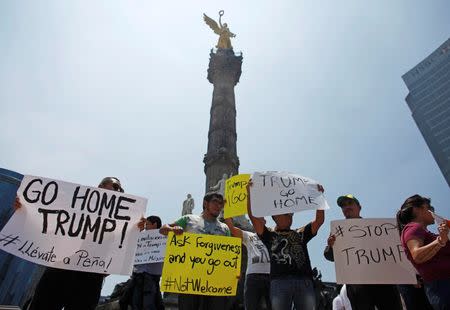 Demonstrators hold placards during a protest against the visit of U.S. Republican presidential candidate Donald Trump, at the Angel of Independence monument in Mexico City, Mexico, August 31, 2016. REUTERS/Tomas Bravo