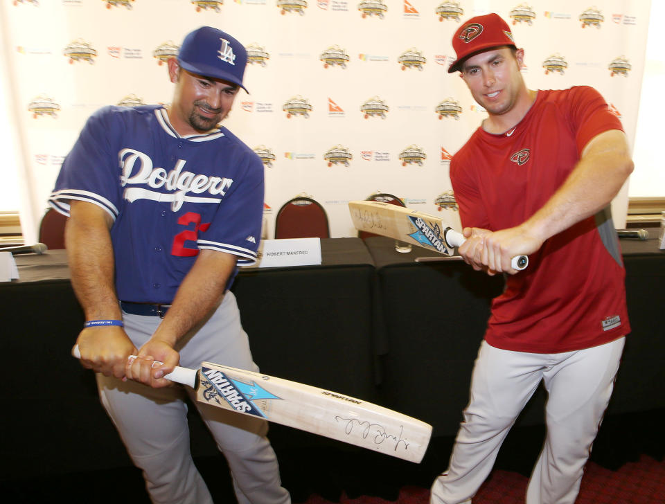 The Los Angeles Dodgers' Adrian Gonzalez, left, and The Arizona Diamondbacks' Paul Goldschmidt try swinging cricket bats at the Sydney Cricket Ground in Sydney, Tuesday, March 18, 2014. The MLB season-opening two-game series between the Los Angeles Dodgers and Arizona Diamondbacks in Sydney will be played this weekend. (AP Photo/Rick Rycroft)