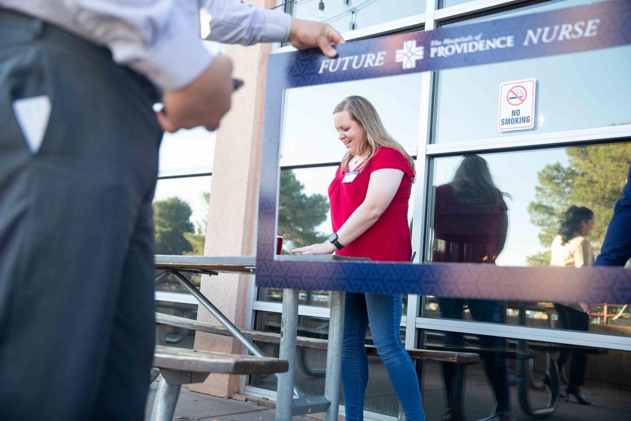 NMSU student Michelle Esqueda, left, gets ready to take a photo with The Hospitals of Providence staff at Bosque Brewing Co. on Wednesday, April 27, 2022. The Hospitals of Providence are offering new nurses sign on bonuses as large as $30,000.