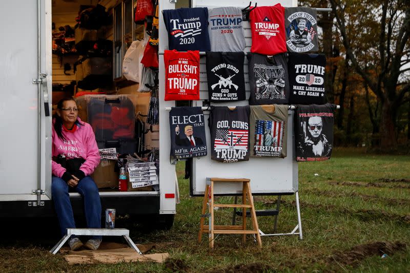 A vendor sells merchandise to supporters of U.S. President Trump as they wait in line to attend his campaign event in Erie