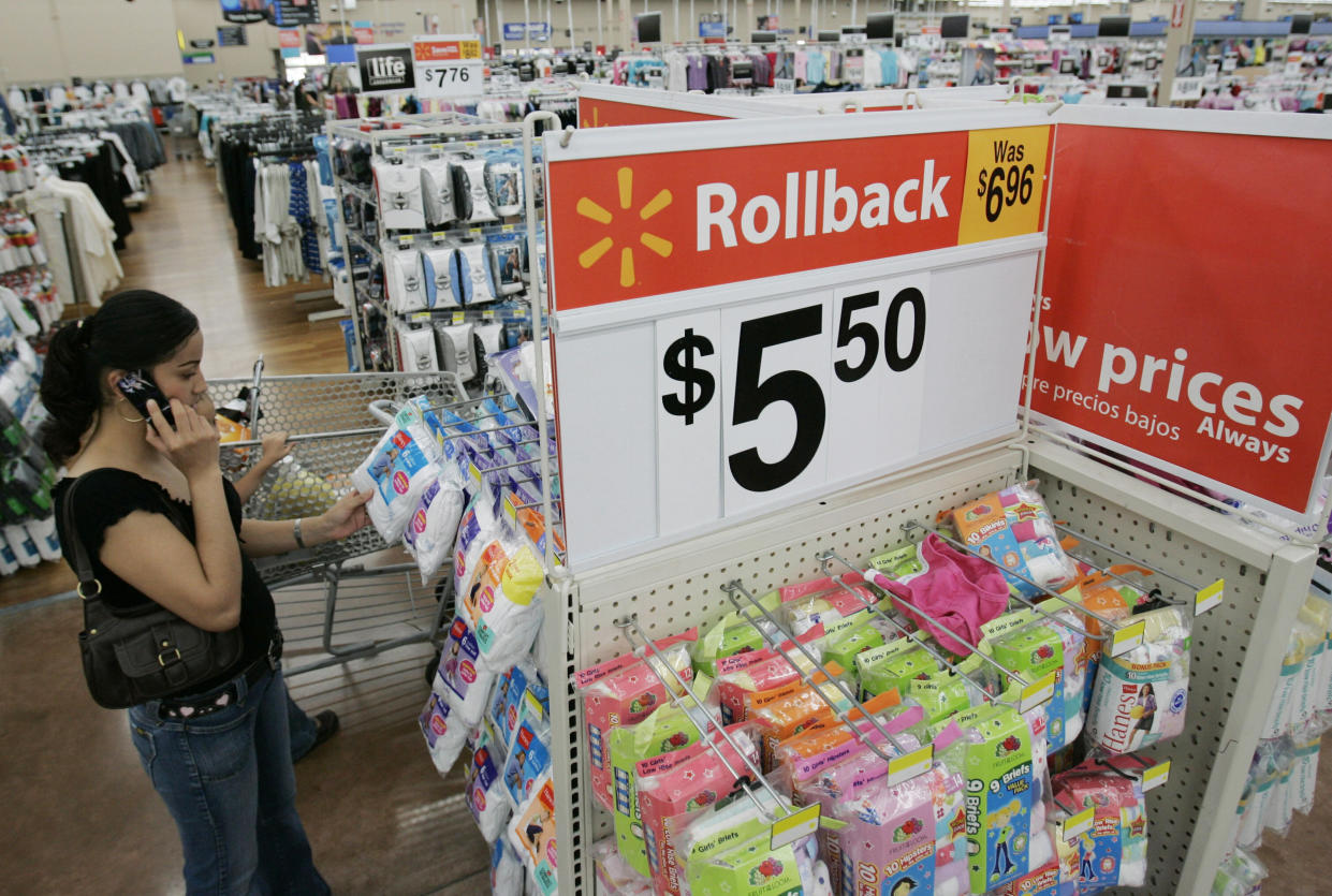 Walmart customer shops next to advertisement at Walmart in San Jose, Calif., Wednesday, Aug. 13, 2008. (AP Photo/Paul Sakuma)