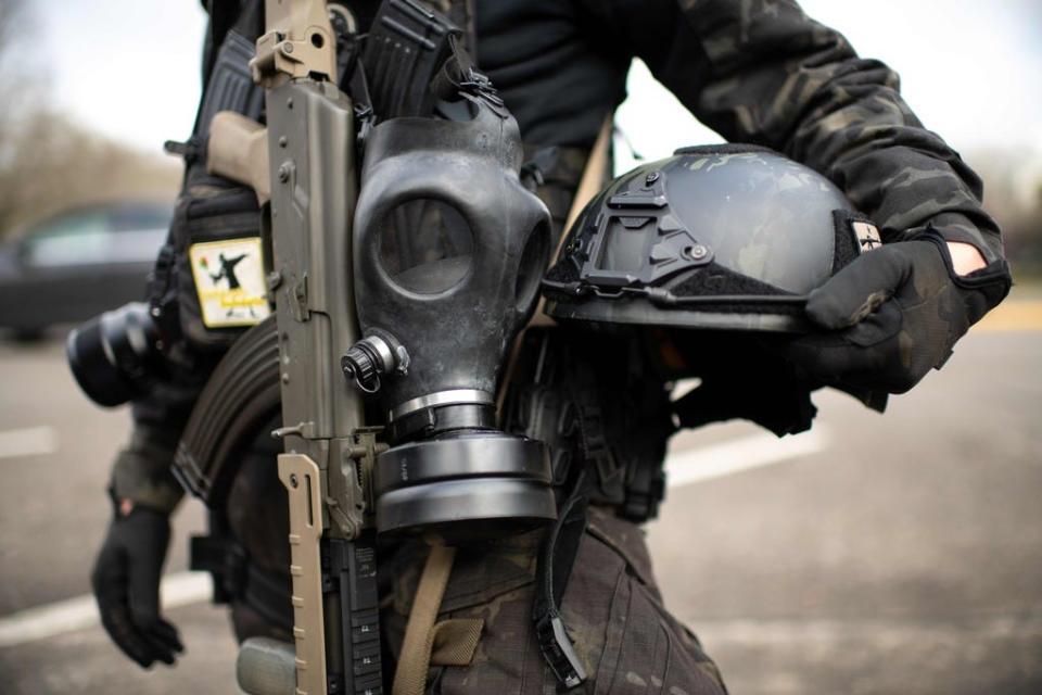 In this file photo taken on January 17, 2021 a member of the Boogaloo Boys stands armed with an assault rifle, gas mask and combat helmet outside of the Oregon State Capitol building in Salem, during a nationwide protest called by anti-government and far-right groups supporting US President Donald Trump and his claim of electoral fraud in the November 3 presidential election.