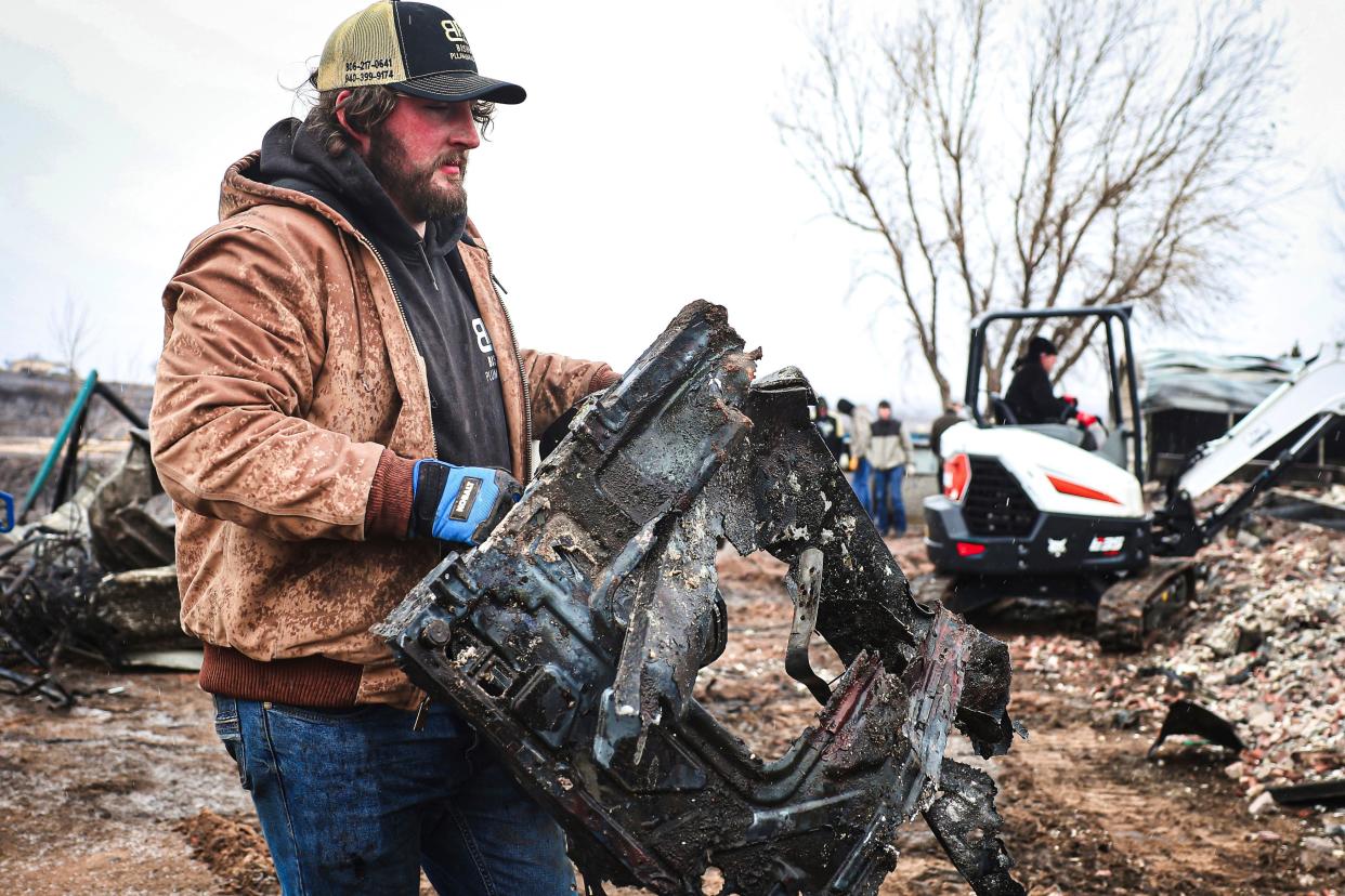 Hunter Cooper helps clean up the Sanchez residence in the snow, Thursday, Feb. 29, 2024, in Canadian, Texas.