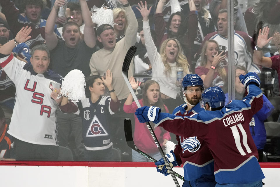 Colorado Avalanche center Darren Helm, left, celebrates his goal against the Tampa Bay Lightning with center Andrew Cogliano (11) during the second period in Game 2 of the NHL hockey Stanley Cup Final, Saturday, June 18, 2022, in Denver. (AP Photo/John Locher)