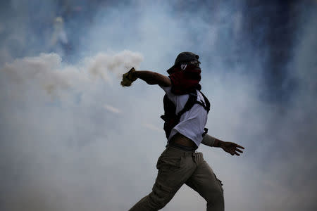 Demonstrator throws back a tear gas canister during rally against Venezuela's President Nicolas Maduro in Caracas, Venezuela May 1, 2017. REUTERS/Marco Bello