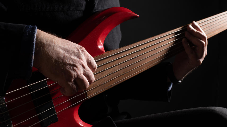 Close-up of man playing fretless 6-string bass