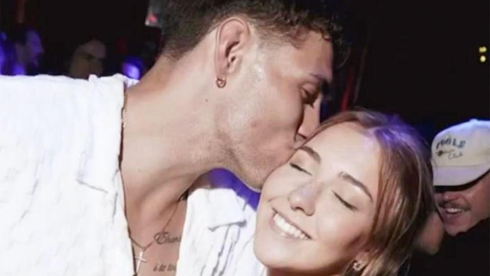 This photo shows Liam Hampson smiling in the background of a photo before his death at a Barcelona nightclub. 