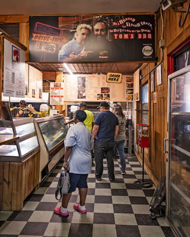 <p>Robbie Caponetto</p> Customers line up to order from the extensive menu, featuring smoked sausages and rib tips as well as deli sandwiches as a nod to the history of the place.