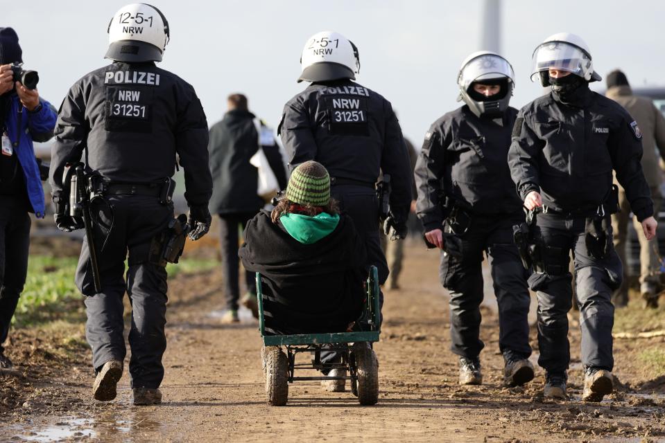 Police cart away an environmental activist from the settlement of Luetzerath, next to the Garzweiler II open cast coal mine on January 11, 2023, near Erkelenz, Germany. / Credit: Andreas Rentz/Getty