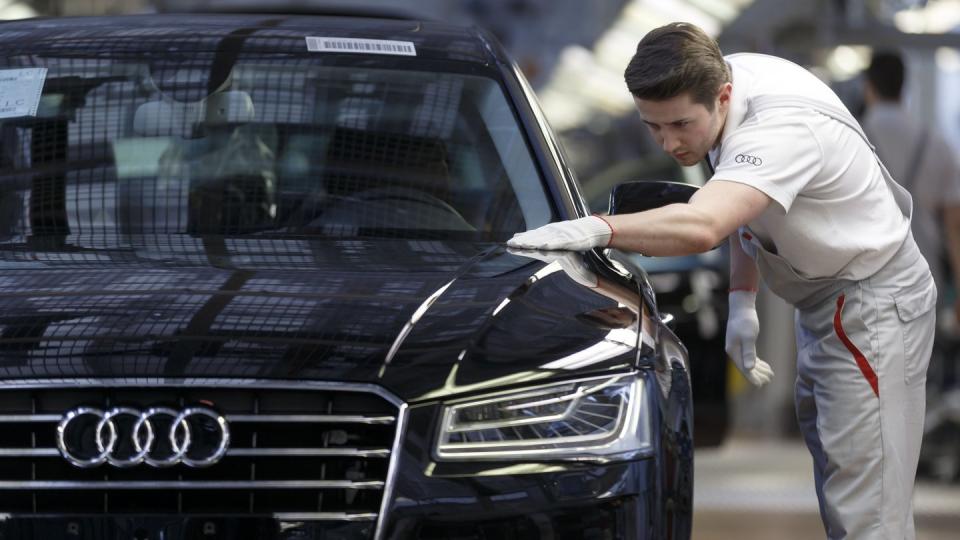 Ein Werksmitarbeiter kontrolliert in einer Produktionshalle von Audi an einem Bandende einen A8.